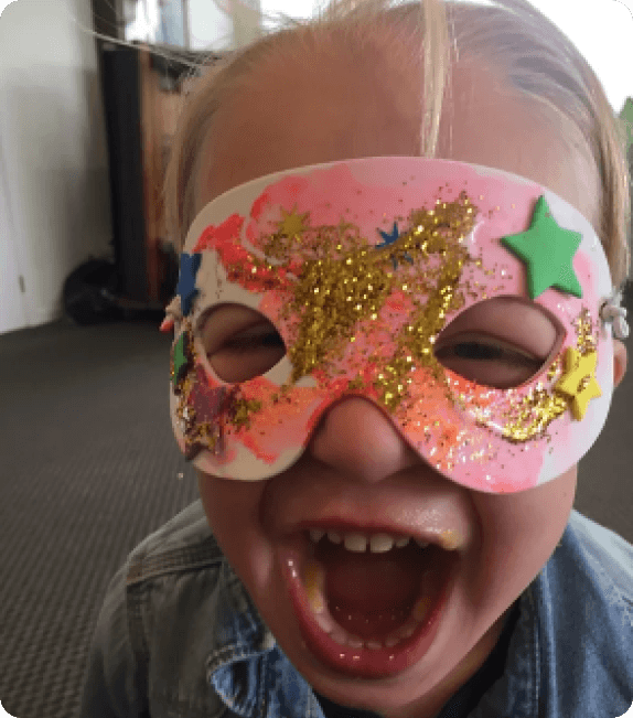 a child wearing a glittery mask, adding a touch of sparkle to their outfit