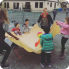 children happily playing with a large sheet of fabric in a fun and creative outdoor activity