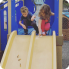 two kids having fun on a playground slide